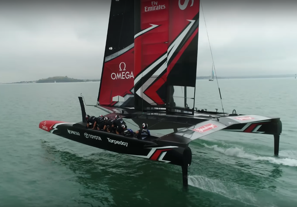 Emirates Team New Zealand in navigazione. Si possono notare a metà dello scafo i membri dell'equipaggio nelle postazioni di grinding  a pedali