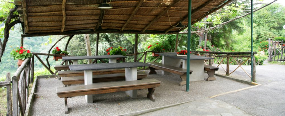 I tavoli esterni dell'osteria U Santu, immersi nel verde che circonda la villa