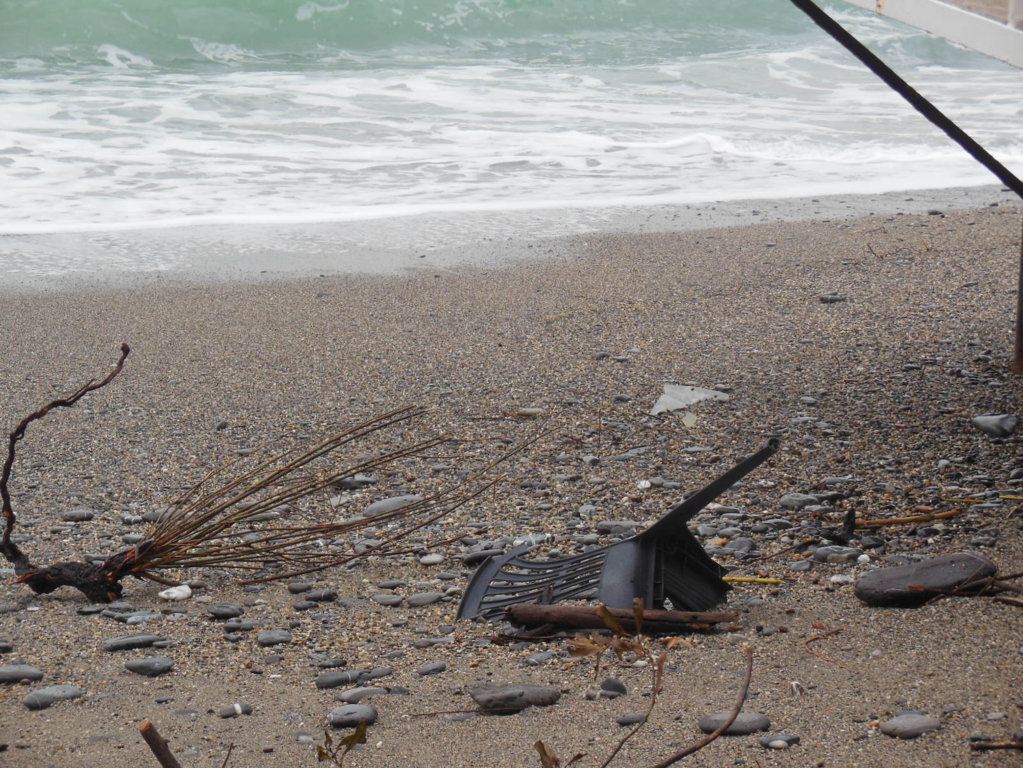 una sedia rotta sulla spiaggia dopo la mareggiata ne Tigullio