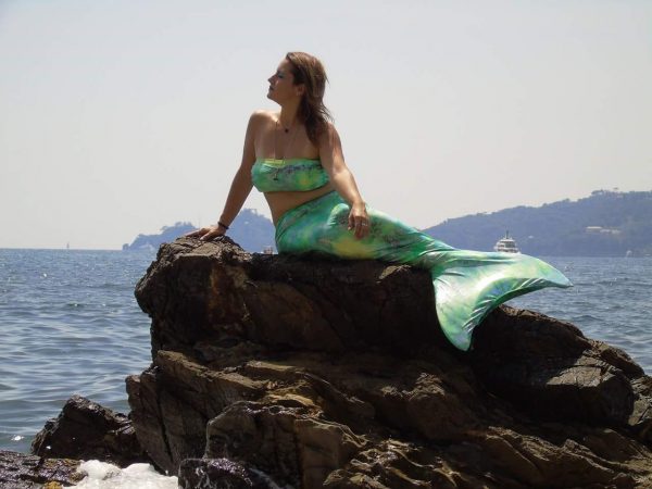 una delle pose sugli scogli che possono far parte di un corso di mermaiding a Rapallo